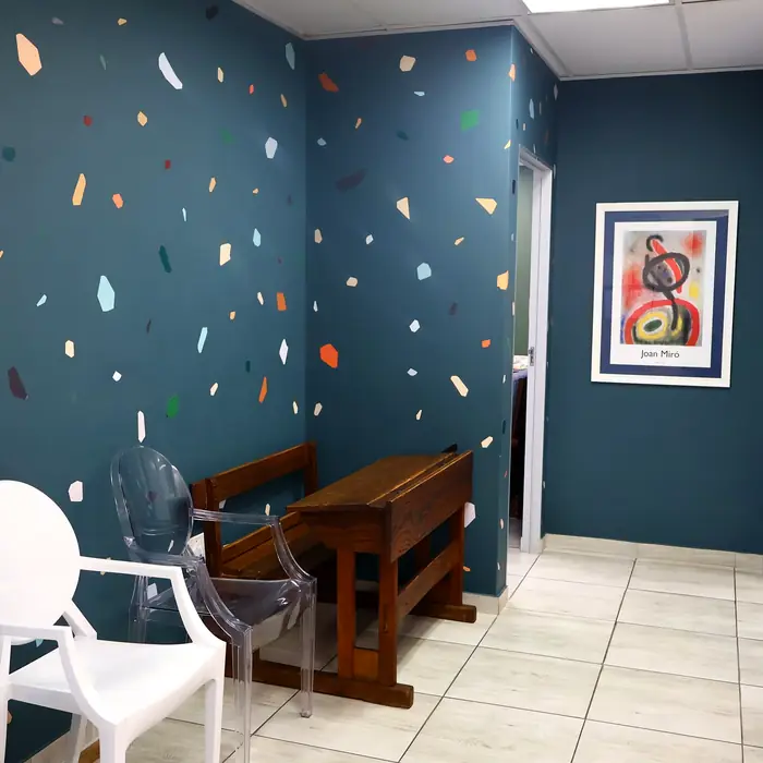 Child-friendly waiting area with a wooden desk and bright wall